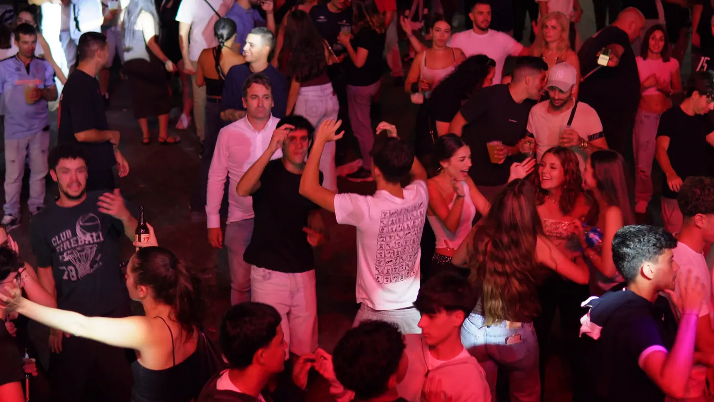 The crowd beneath red lights